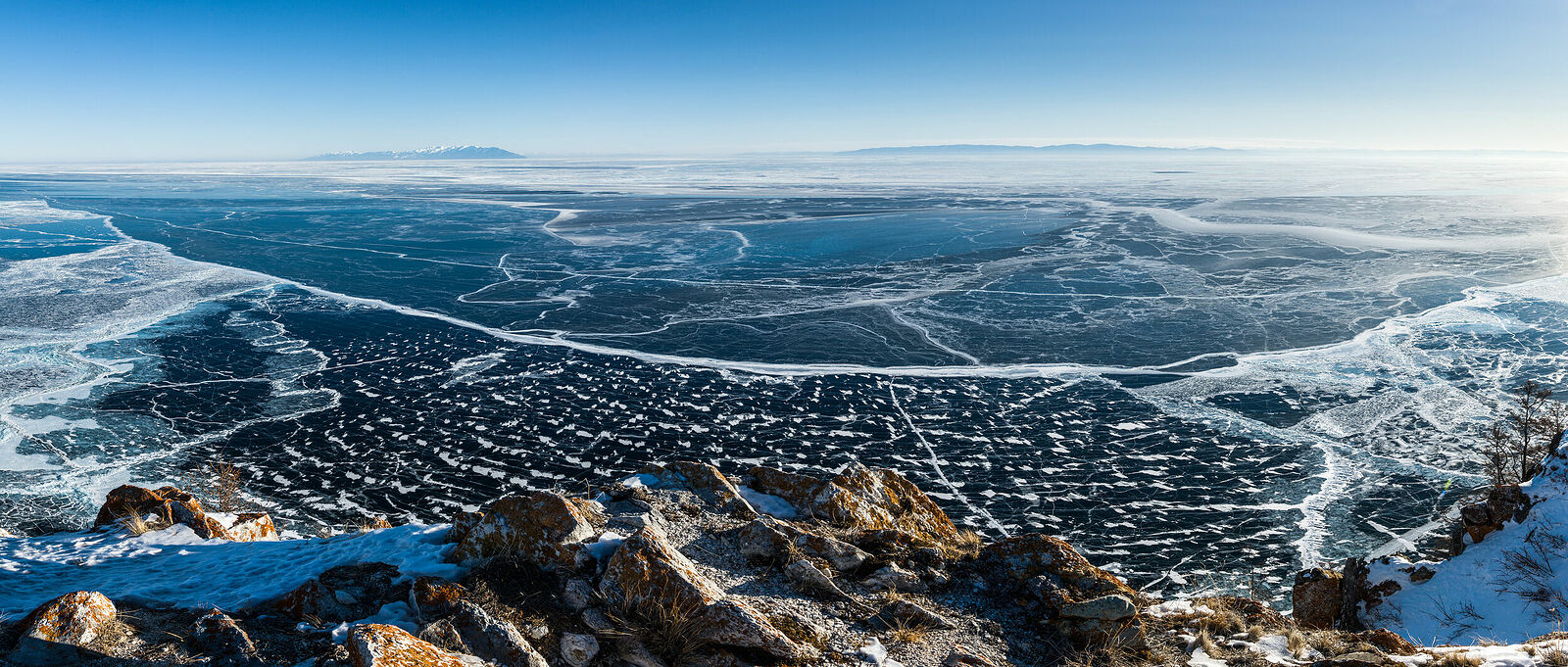 Панорама Байкала с горы Толгой около посёлка Узуры на северо-восточной оконечности острова Ольхон. Именно здесь находится наиболее глубоководная часть озера. Первый лёд в акватории. На дальнем плане - полуостров Святой Нос.